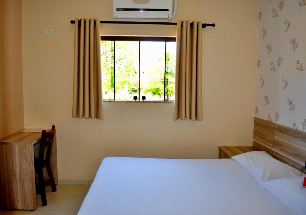 欧里尼奥斯Hotel Maranhão的一间卧室设有一张床和一个窗口