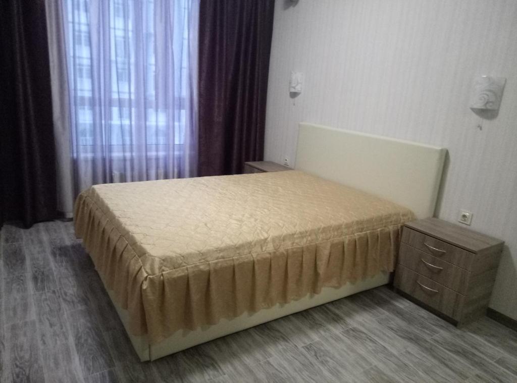 基辅Apartment complex Parklend的一间卧室配有一张床、一个梳妆台和一扇窗户。