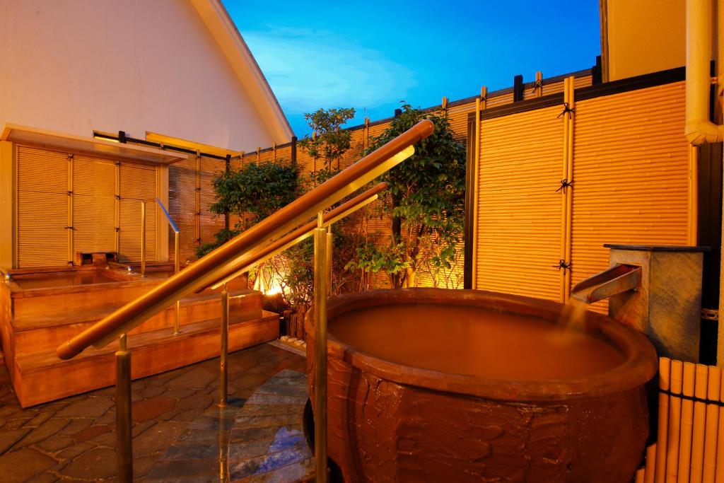 神户御幸庄花结阿里马温泉日式旅馆的一座大型木浴缸,位于一座建筑的侧面