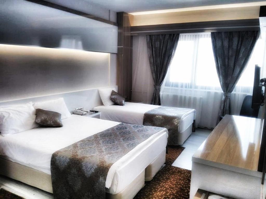 代尼兹利纳帕酒店的酒店客房,设有两张床和一张沙发