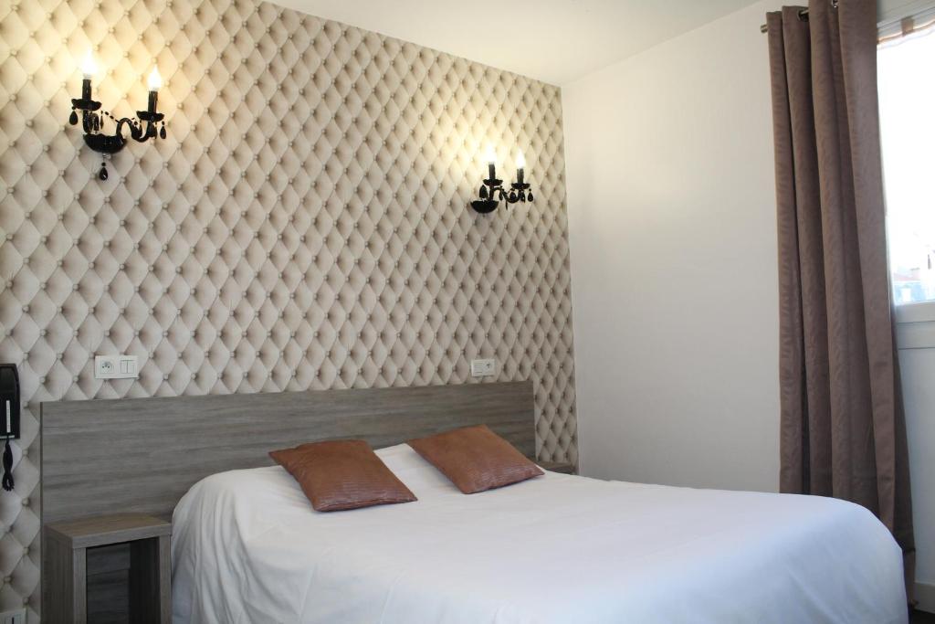 克莱蒙费朗比尤利酒店的一间卧室配有一张带两个枕头的床