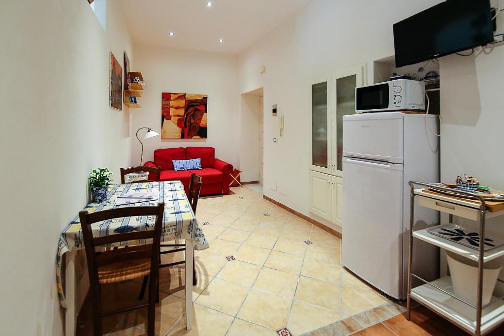锡拉库扎福斯托公寓的厨房配有桌子和白色冰箱。