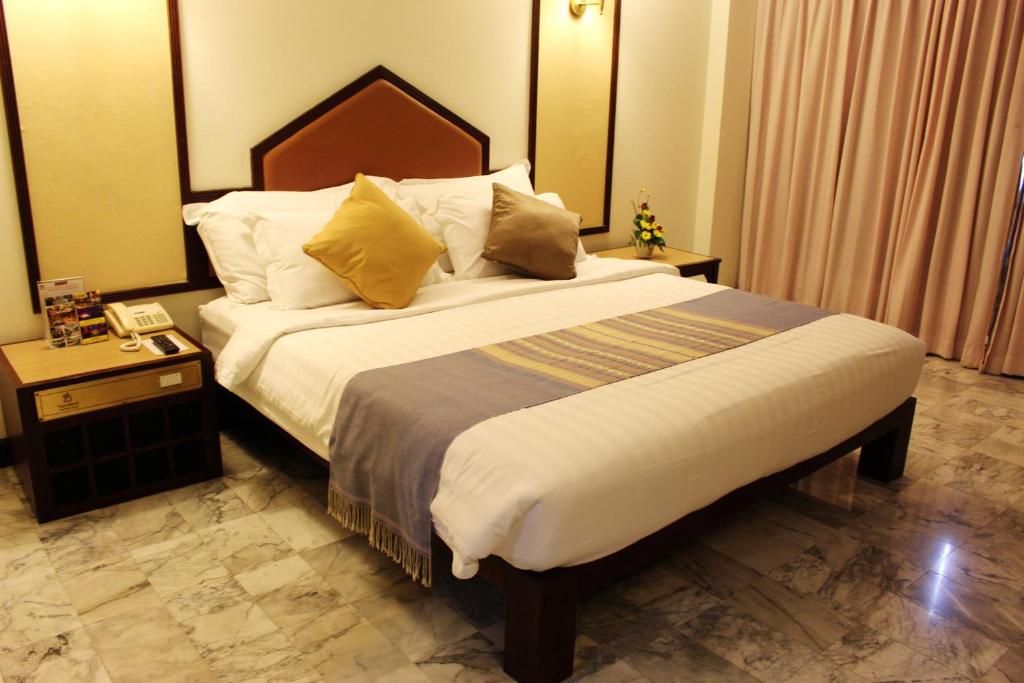程逸府西伊哈拉酒店的一间卧室配有一张大床和木制床头板
