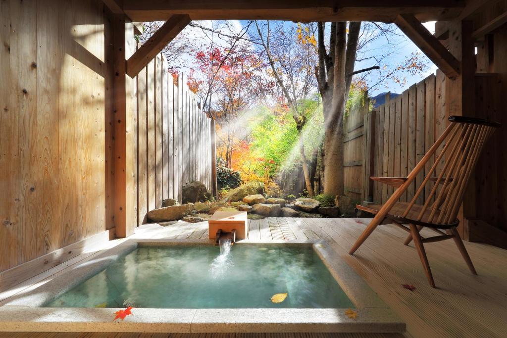 水上町尚文旅馆的后院的热水浴池配有秋千和椅子