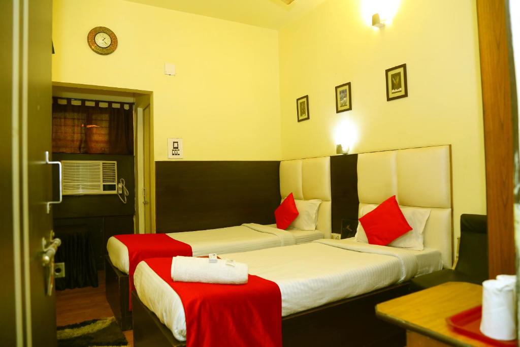贾姆谢德布尔Hotel Holideiinn的酒店客房 - 带两张带红色枕头的床