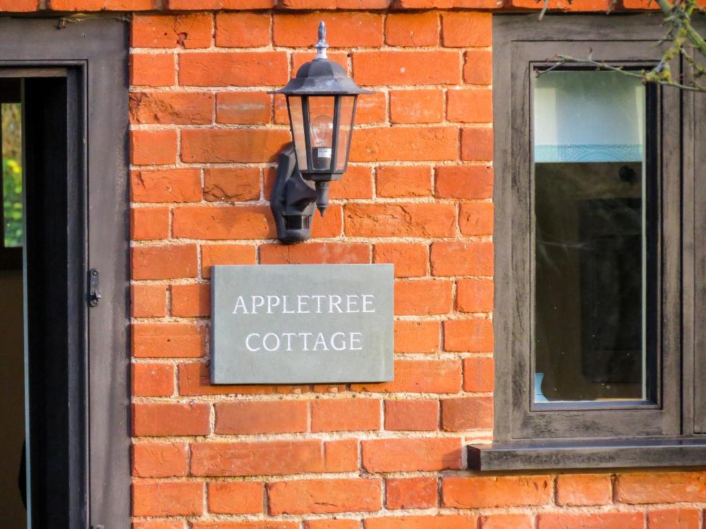 FressingfieldAppletree Cottage Fressingfield的砖墙边的标志