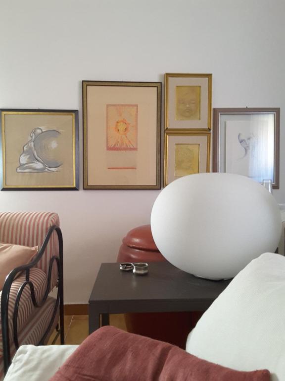 福利尼奥B&B I Sassetti的客厅配有桌子和墙上的照片