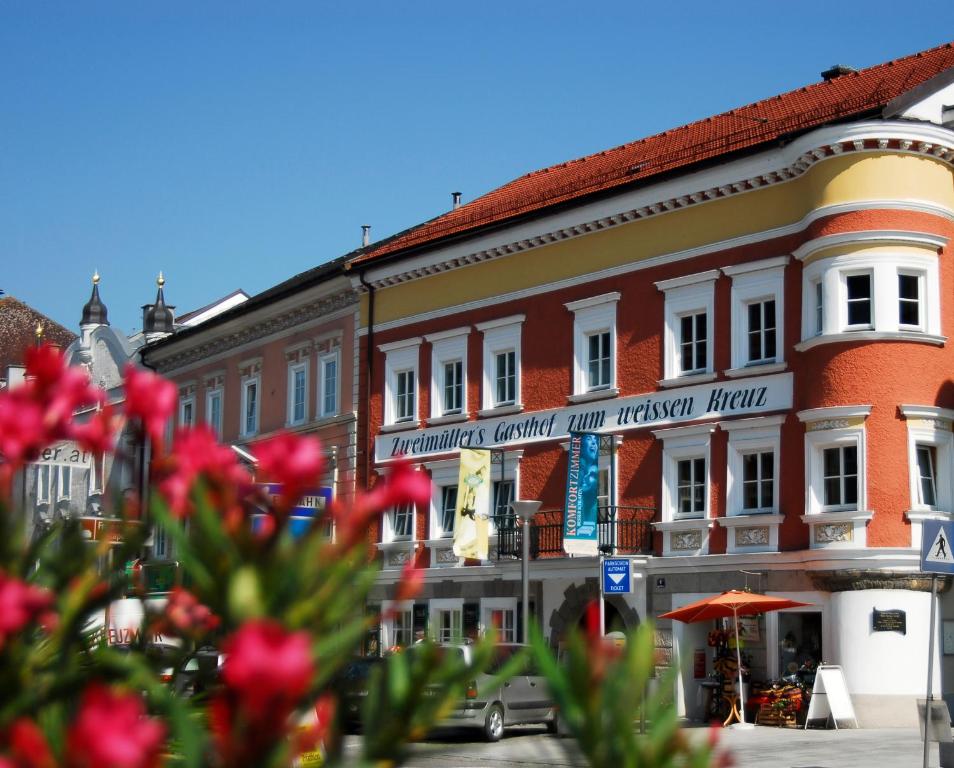 格里斯基兴Gasthof Hotel Zweimüller的街上一群种着红花的建筑