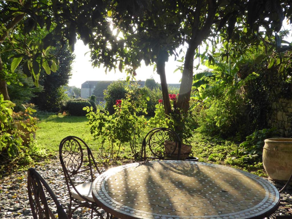 迪南Appartement des Remparts的阳光明媚的花园中的桌椅