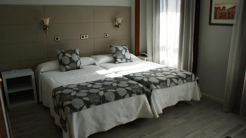 卡塞雷斯洛斯那然约斯酒店的一间卧室设有一张大床和大窗户