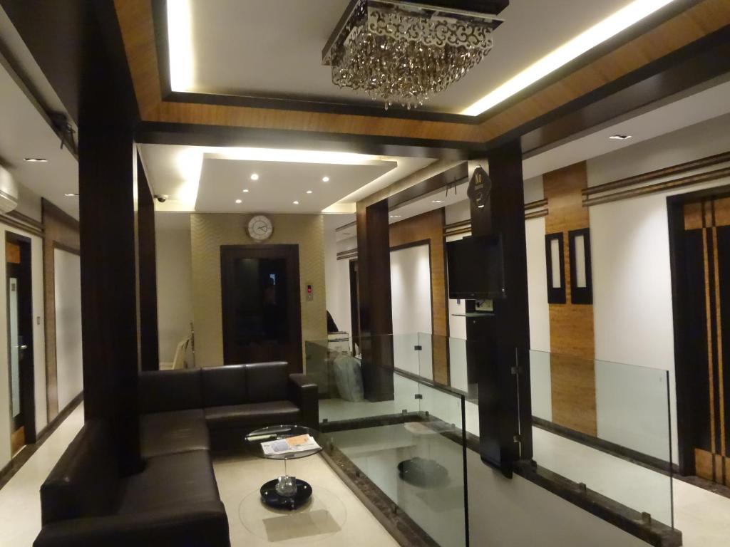 孟买Hotel Causeway, Colaba的带沙发和镜子的客厅