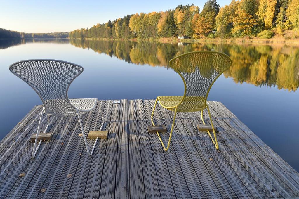 Smārde瓦古马帕苏尔旅馆的两把椅子坐在湖边的码头上