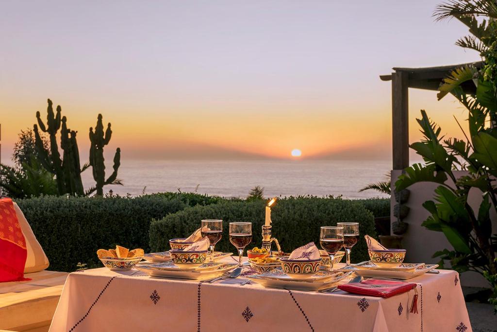 米勒福特Aftas Trip的日落时分带酒杯和海洋的桌子