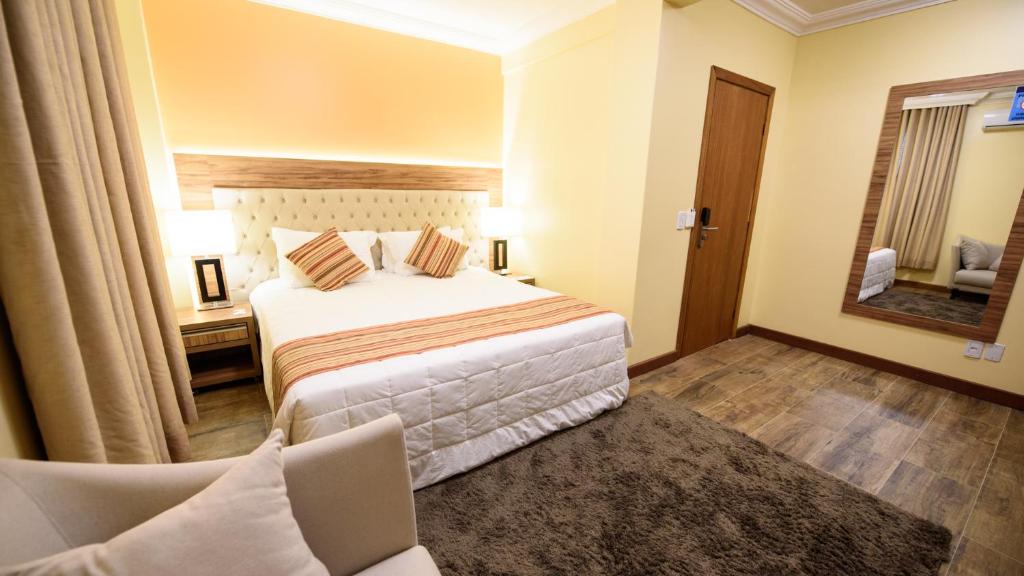 佩洛塔斯Hotel Alles Blau的一间卧室配有一张床、一把椅子和镜子