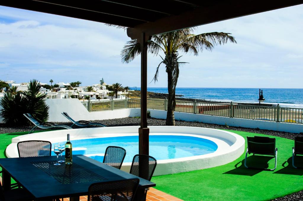 宏达海滩Villa La Concha的一个带桌椅的海洋游泳池