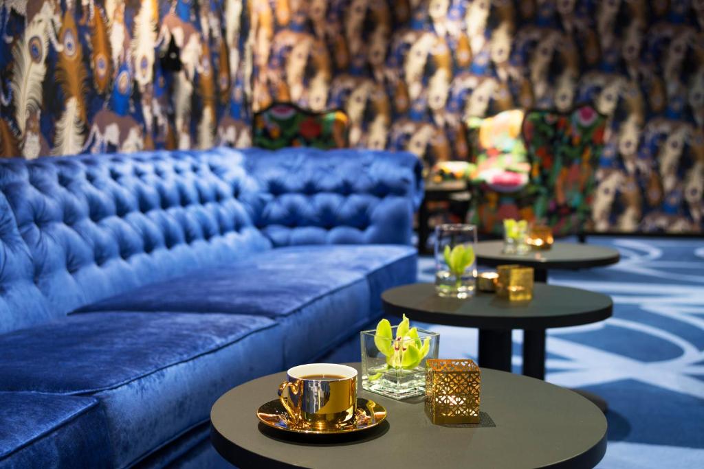奥斯陆涩恩特米纳斯酒店的客厅配有蓝色的沙发和2张桌子