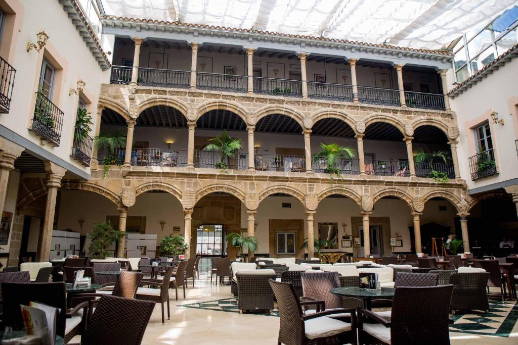 阿维拉洛维拉达宫酒店的一座空旷的庭院,里面设有桌椅