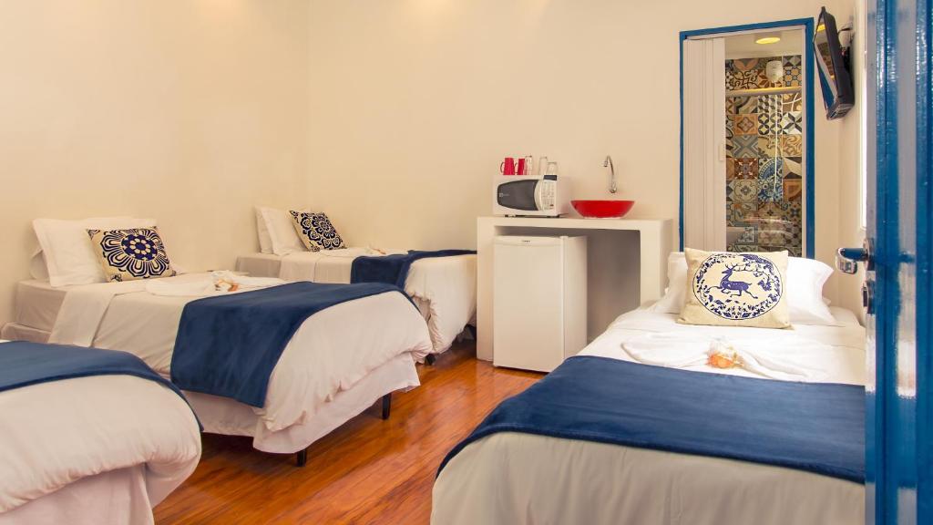 圣保罗Pousada e Hostel São Paulo Comfort的带3张床和蓝色及白色枕头的客房