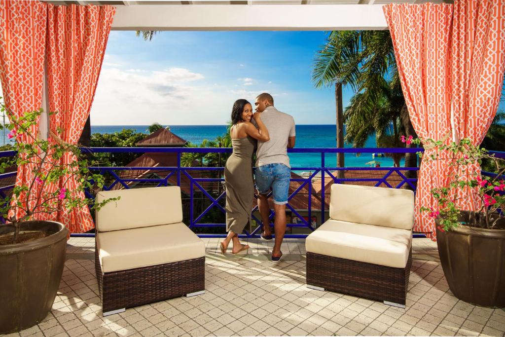 蒙特哥贝德雅全包度假酒店 的一对夫妇站在度假胜地的阳台上