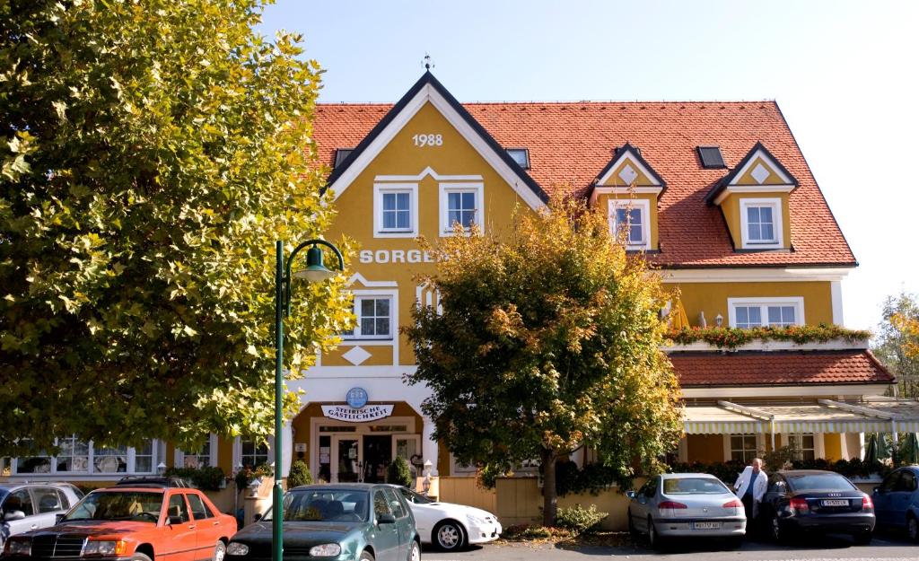 Frauental an der Lassnitz Sorgerhof的一座黄色的大建筑,前面有汽车停放