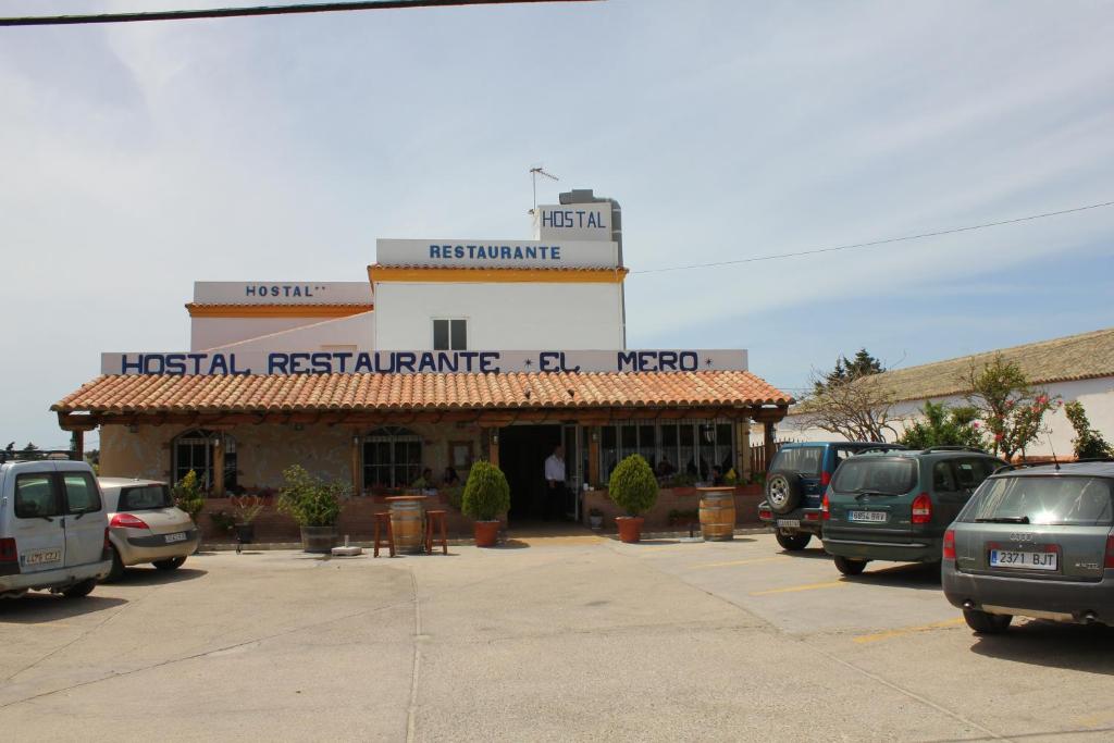 扎霍拉Hostal Cafeteria El Mero的停车场,有汽车停在餐厅前