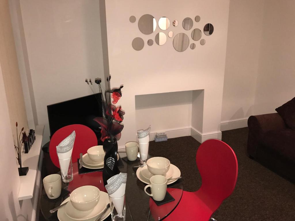 赫尔JO Wordsworth Apartment的客厅配有红色椅子和桌子