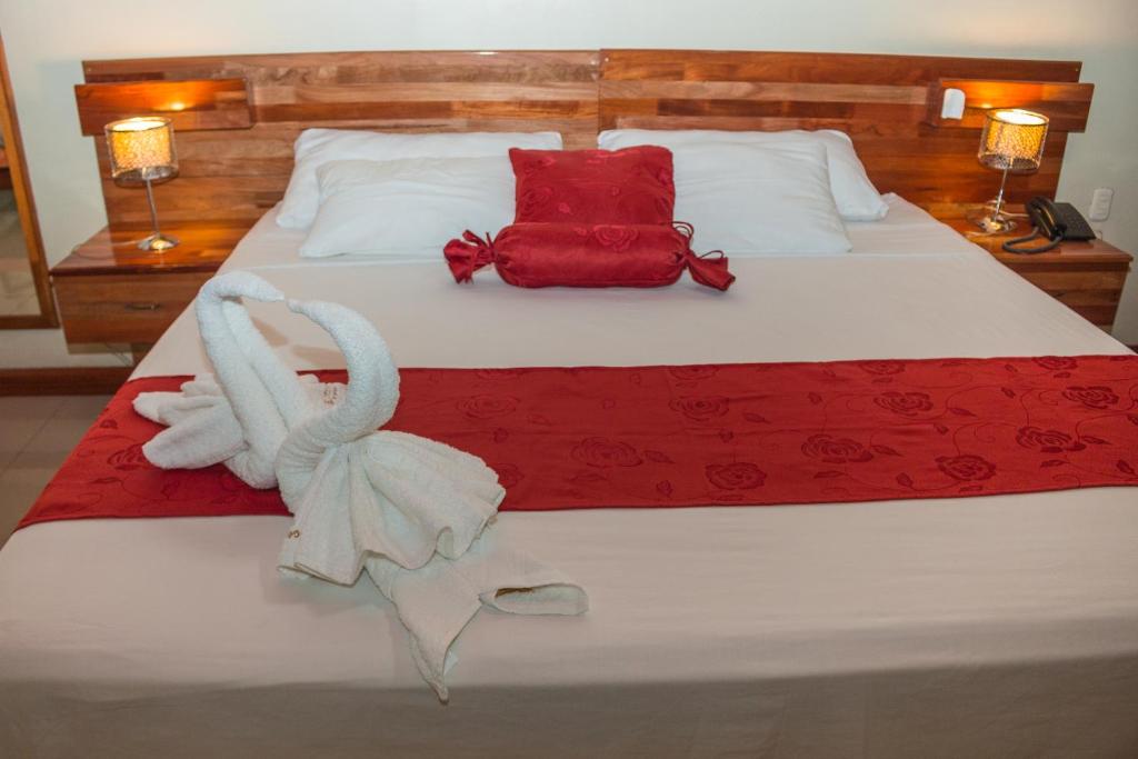 伊基托斯金星酒店的一间卧室配有一张带红白毯子的床