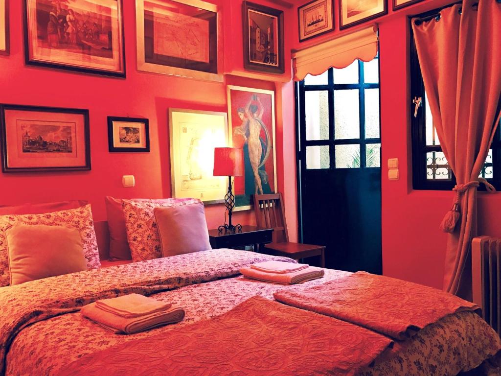 马科普隆韦瑞洛纳画廊地下室旅馆的红色卧室,配有带毛巾的床