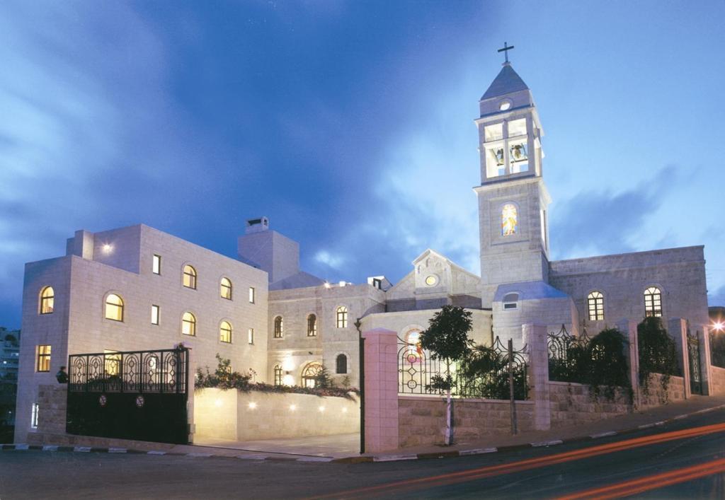 伯利恒Abrahams Herberge - Beit Ibrahem的一座在晚上设有钟楼的大型建筑