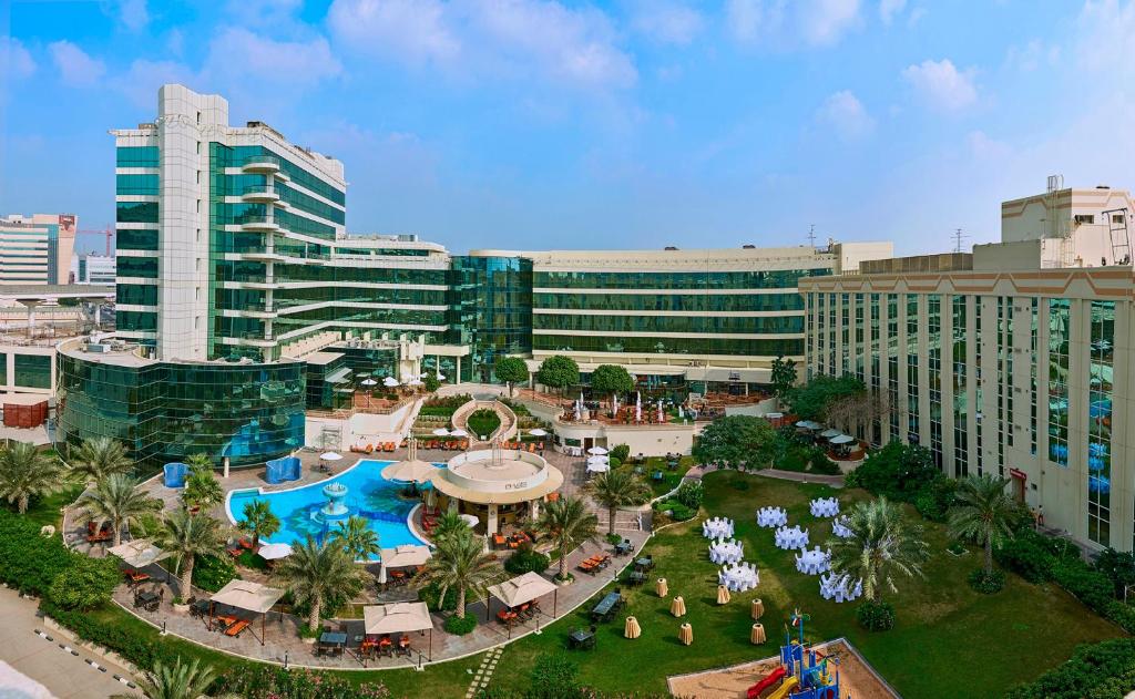 迪拜Millennium Airport Hotel Dubai的享有带游泳池的度假村的空中景致