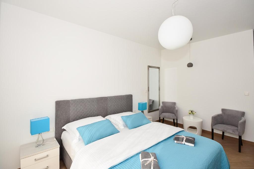 奥拉萨奇Apartment & Room Ladisic的一间卧室配有一张大床和两把椅子