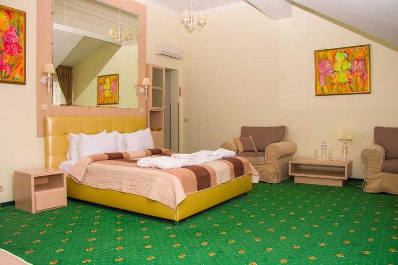 佩列亚斯拉夫-赫梅利尼茨基Hotel and Restaurant Complex Lubokray的一间卧室配有一张大床,铺有绿色地毯
