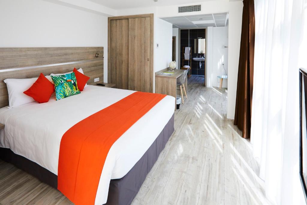 拉佩讷叙尔于沃讷Appart' Hotel La Girafe Marseille Est - Porte d'Aubagne的酒店客房的床铺配有橙色和橙色的毯子