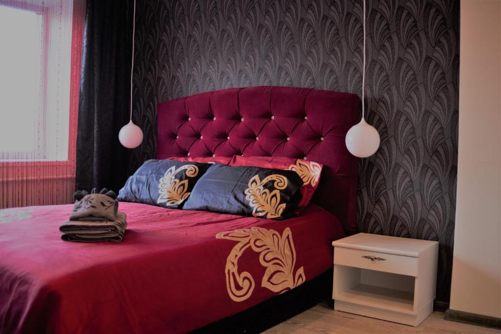 希奥利艾Siauliai Apartments - Ežero的一间卧室配有红色的床和红色床头板