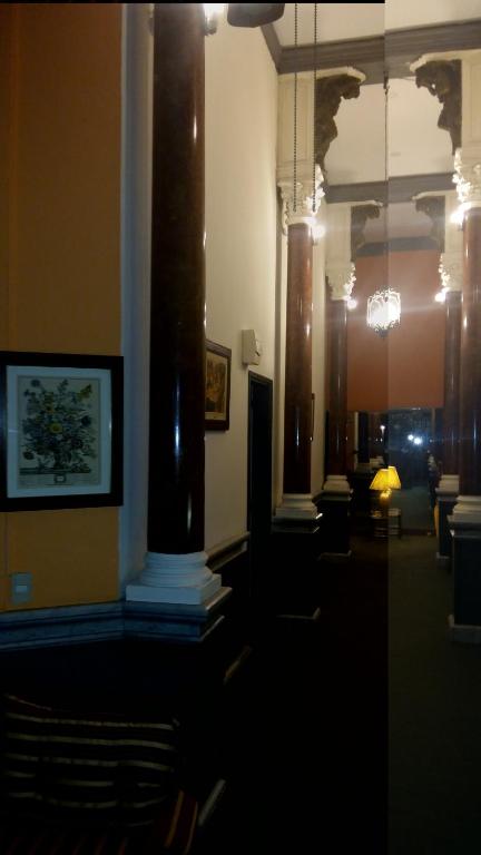 蒙得维的亚乌拉圭酒店的一间带柱子的客厅和一间带沙发的房间