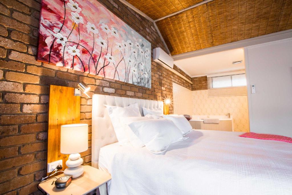 莫韦尔法纳姆阁餐厅汽车旅馆的卧室配有白色的床和砖墙
