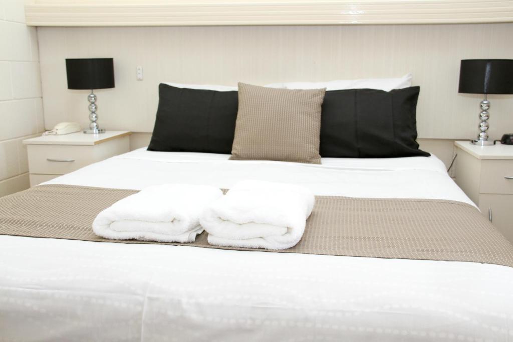 伦马克伦马克汽车旅馆 的卧室配有白色床和毛巾