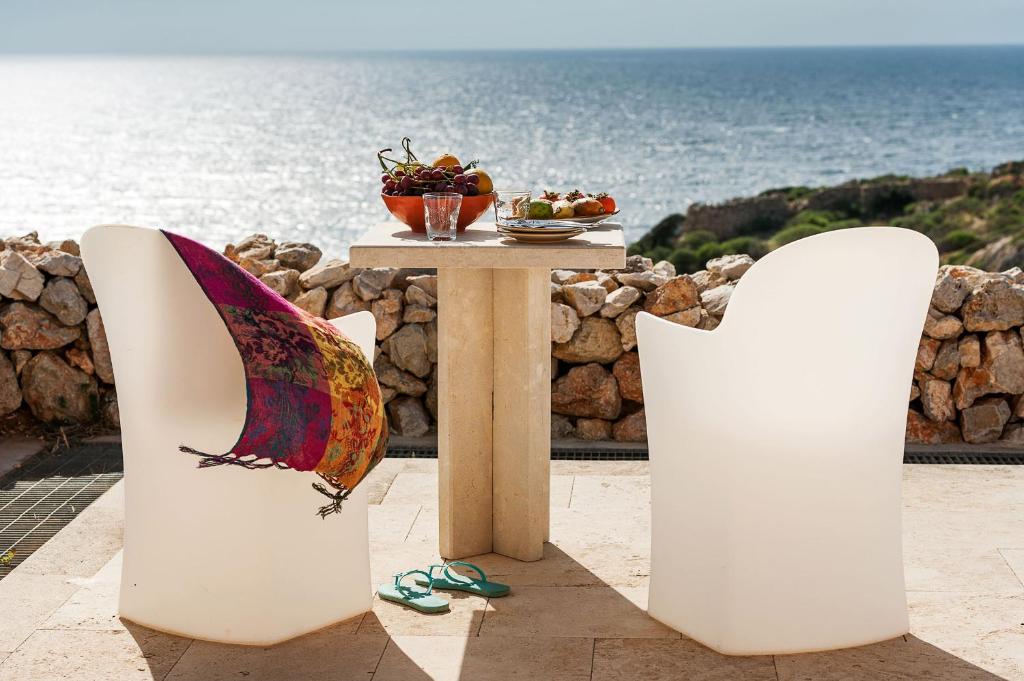 法维尼亚纳Nido Del Pellegrino的一张桌子和椅子,背景是大海