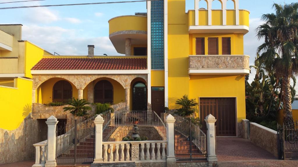 CollepassoB&B La Collina的黄色的房子,前面有楼梯