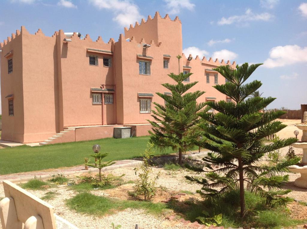 Al Medou达尔埃尔菲达欧斯旅馆的前面有棵树的建筑