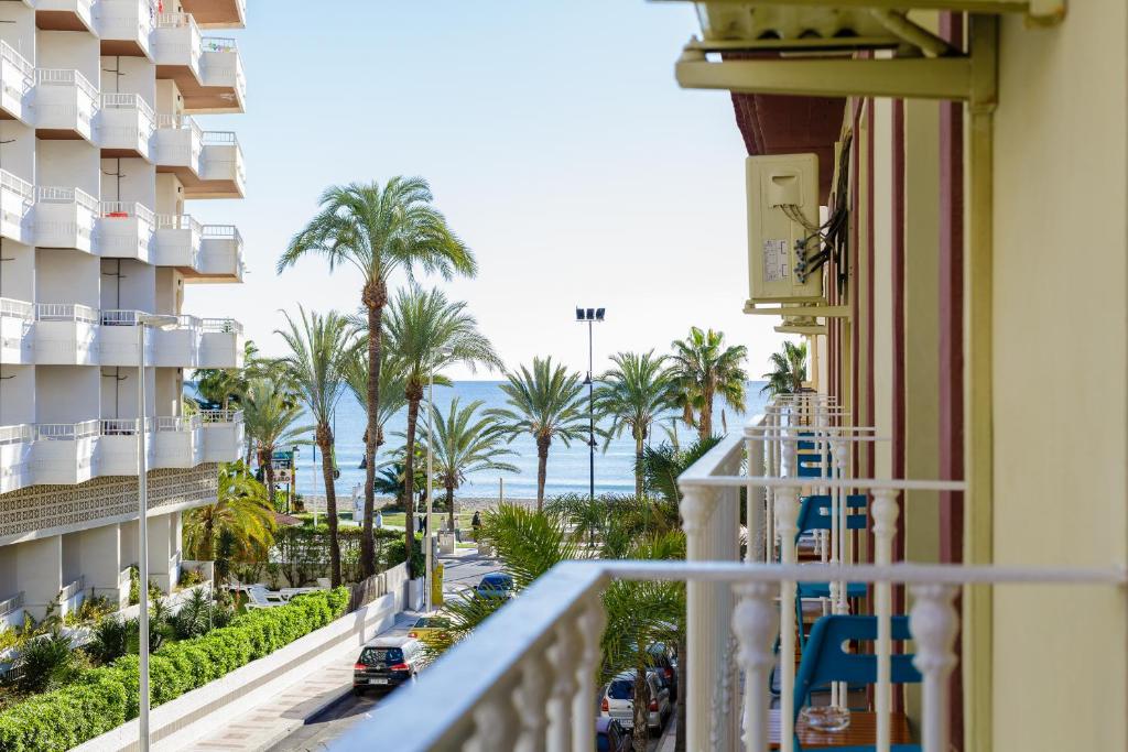 多列毛利诺斯坎迪索尔舒适公寓式酒店的阳台享有大海和棕榈树的景致。