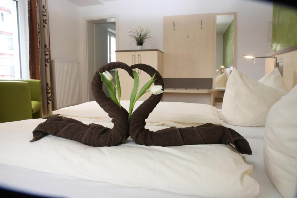 诺德林根Goldener Schlüssel mit Gästehaus Sina的酒店客房的床上配有2条天鹅形毛巾