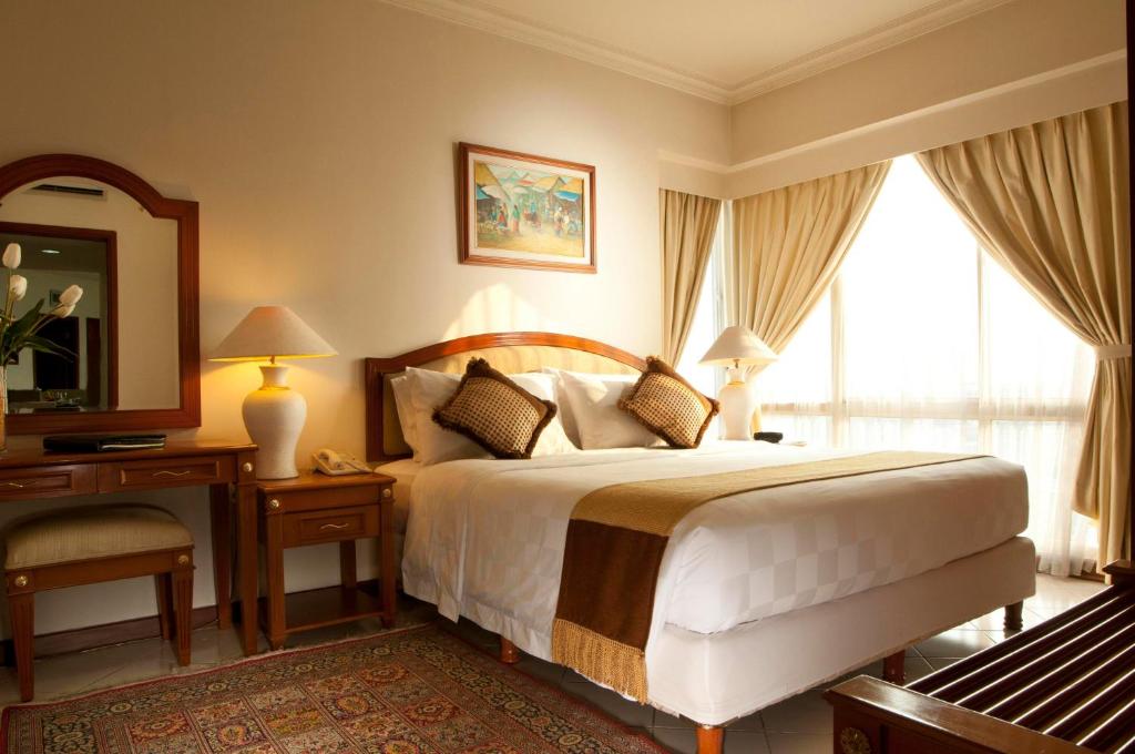 雅加达The Residences at Puri Casablanca的一间卧室配有一张床、一张书桌和一面镜子