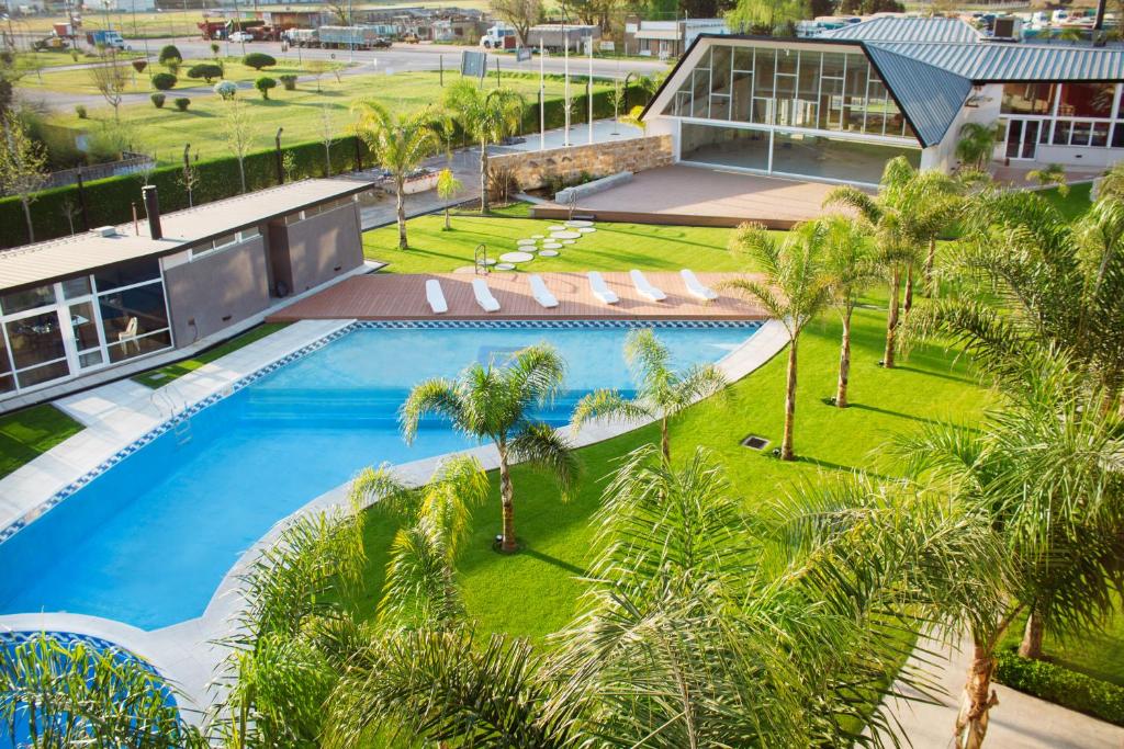 LeonesHotel Posada Maestosso的享有度假村的空中景致,设有游泳池和棕榈树