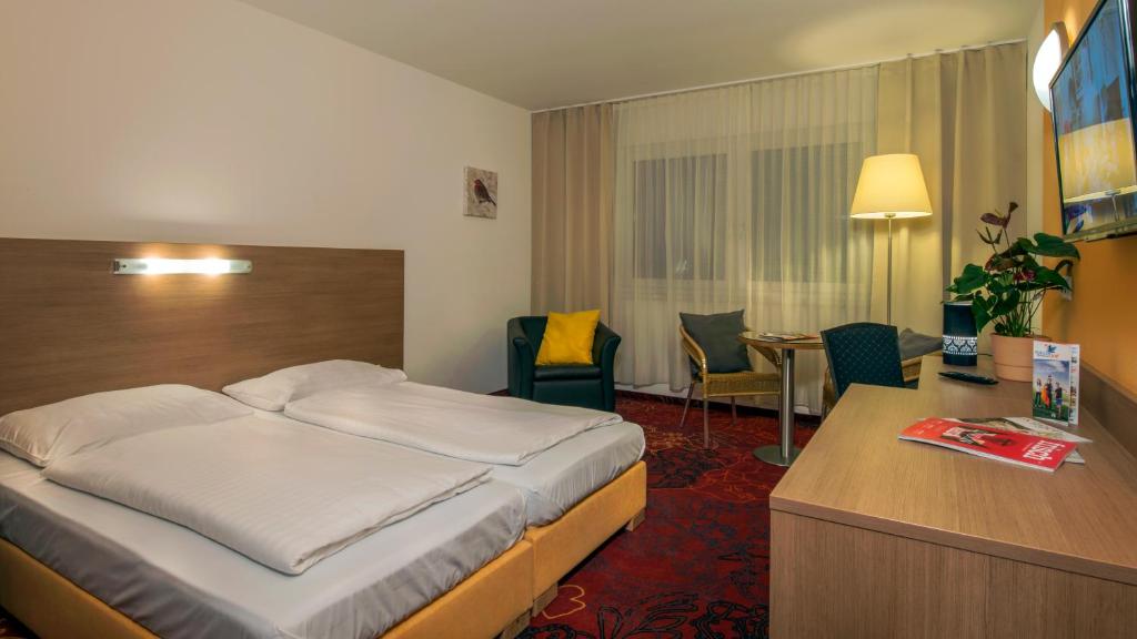 施托克劳凯瑟拉斯特酒店的配有一张床和一张书桌的酒店客房