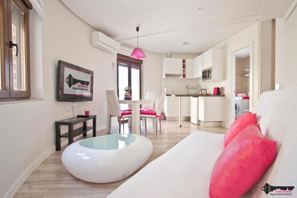 托莱多塞万提斯公寓的客厅配有白色沙发和红色枕头。