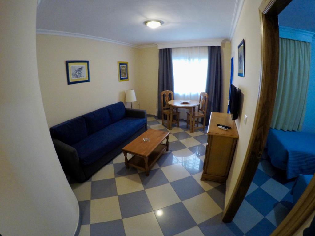 多列毛利诺斯尼娜德奥罗公寓酒店的客厅配有蓝色的沙发和桌子