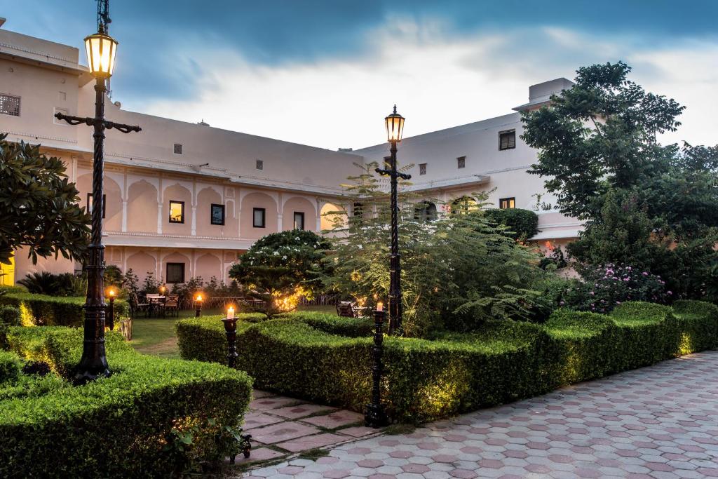斋浦尔哈瓦里文化遗址酒店的一座建筑,设有一座带灌木丛和灯光的庭院
