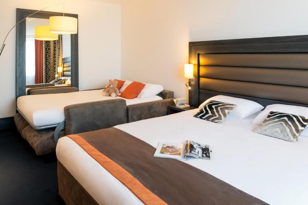 里昂里昂中央美居酒店 - 火车东站店 的酒店客房,设有两张床和镜子