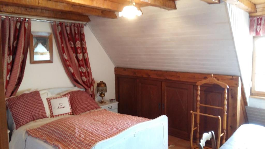 Triembach-au-Val“维涅隆”民宿的一间卧室配有红色窗帘的床